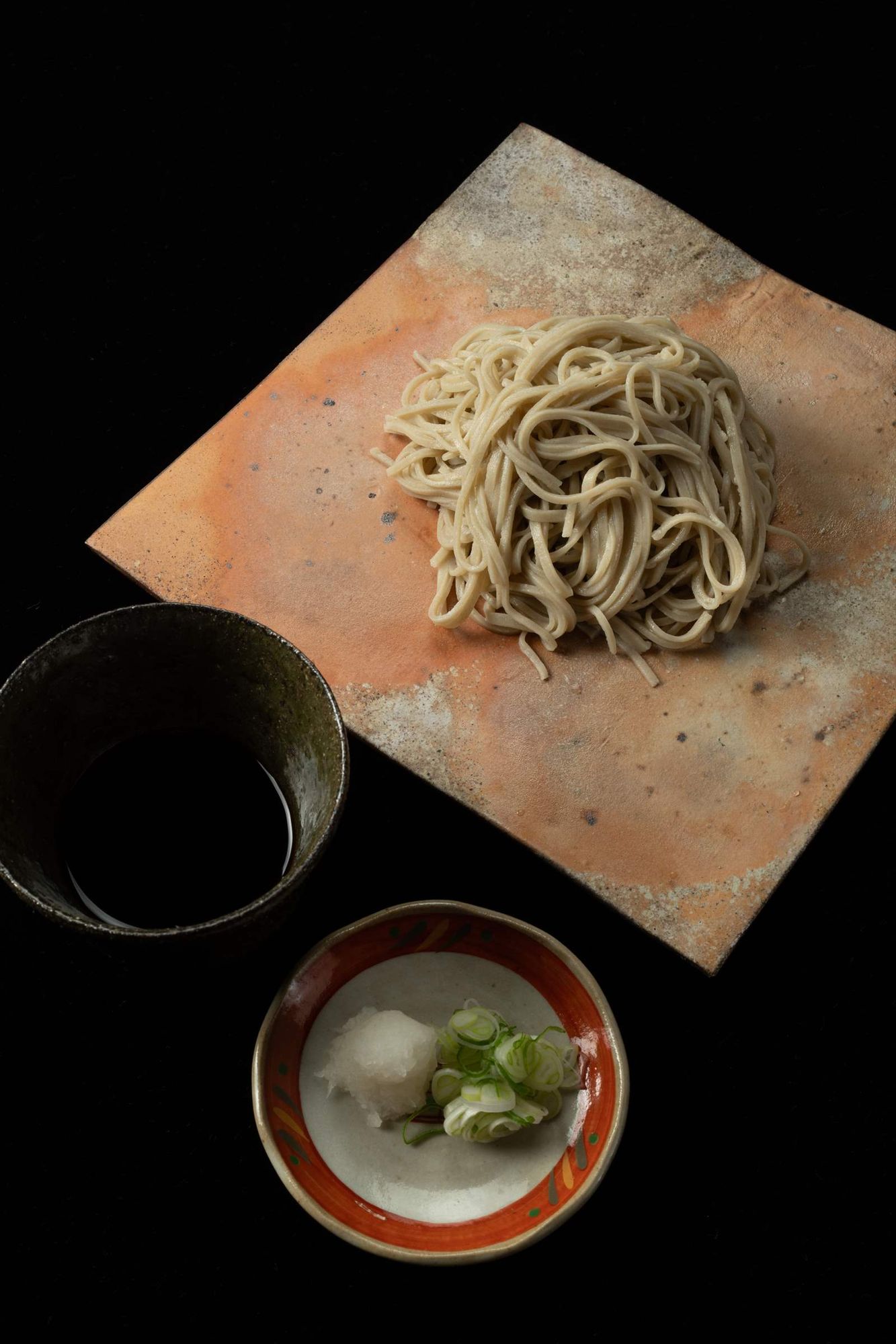 陶板に盛った蕎麦とつゆ