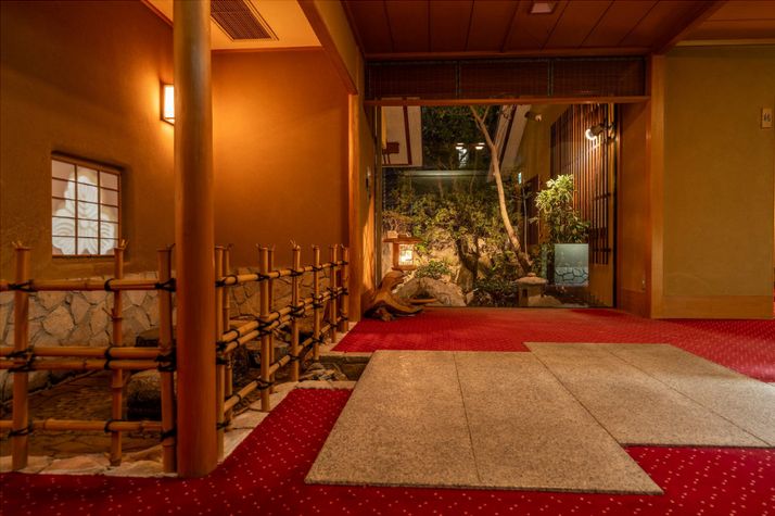 赤い絨毯の玄関ホールと坪庭